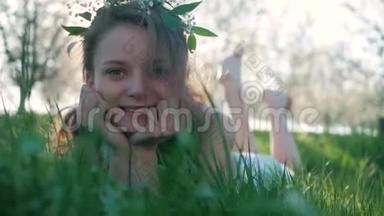 美丽的微笑女孩躺在春天的草甸和野花。 笑和快乐。 享受大自然吧。 美丽的少年